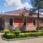 Front view of elegant 3-bedroom all-ensuite house for rent in Karen Bogani, featuring a gated entrance, lush landscaping, and modern design.