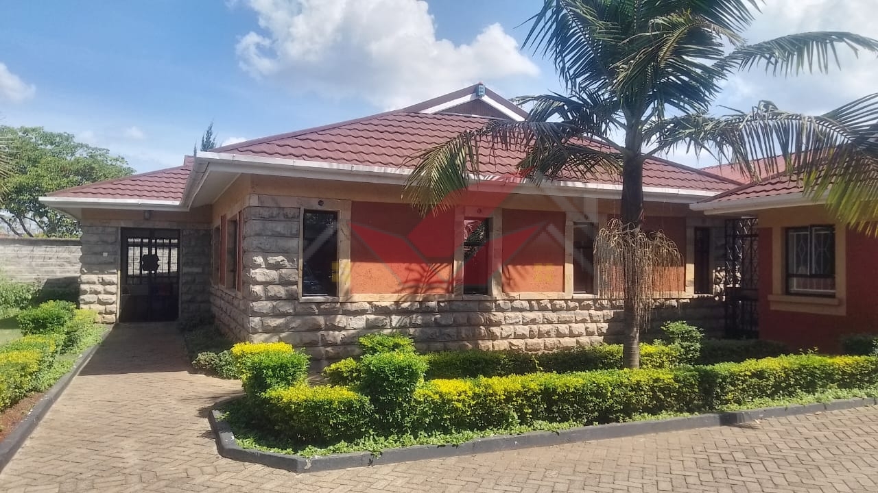 Front view of elegant 3-bedroom all-ensuite house for rent in Karen Bogani, featuring a gated entrance, lush landscaping, and modern design.