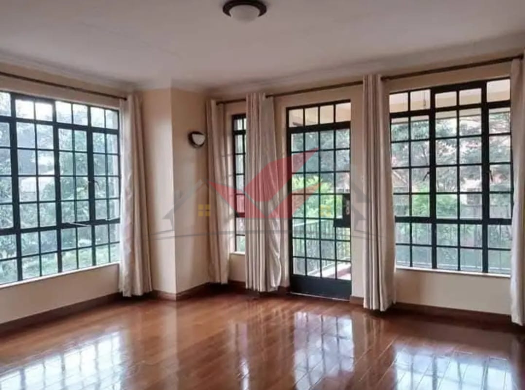 Grand living room with hardwood floors and fireplace in a luxury Karen rental.