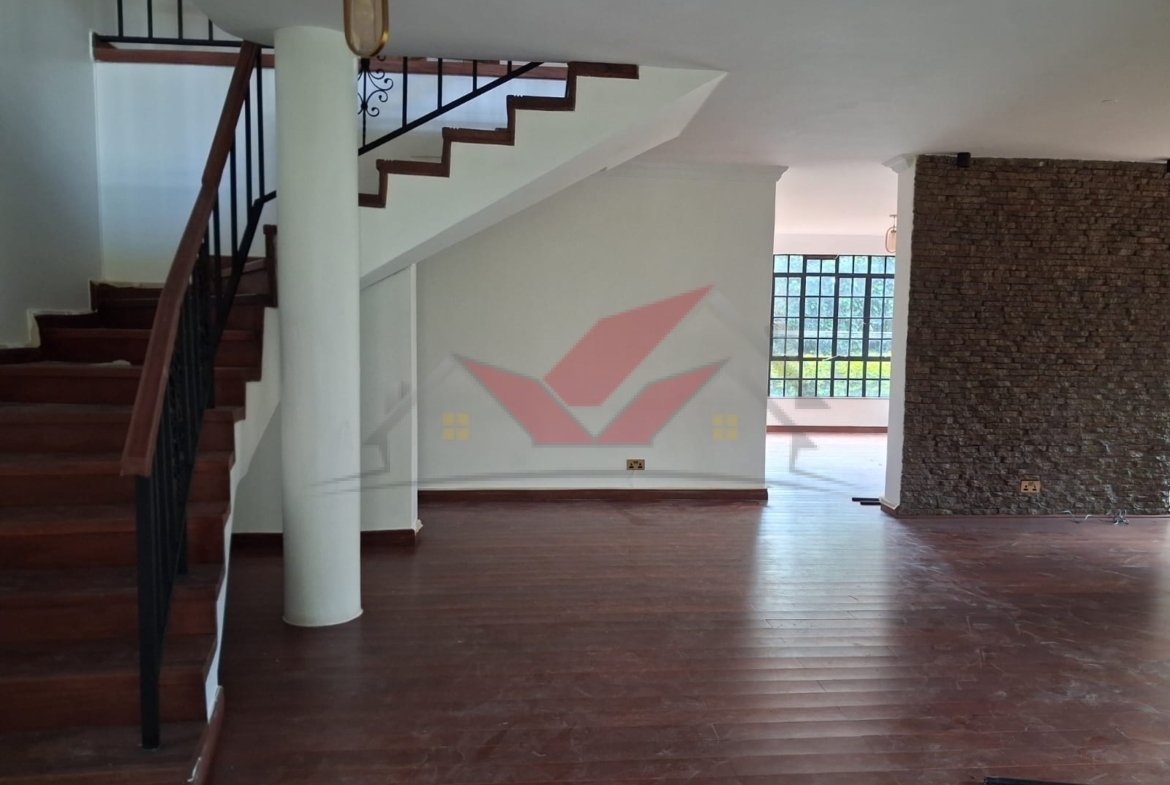 Grand living room with hardwood floors and fireplace in a luxury Karen rental.