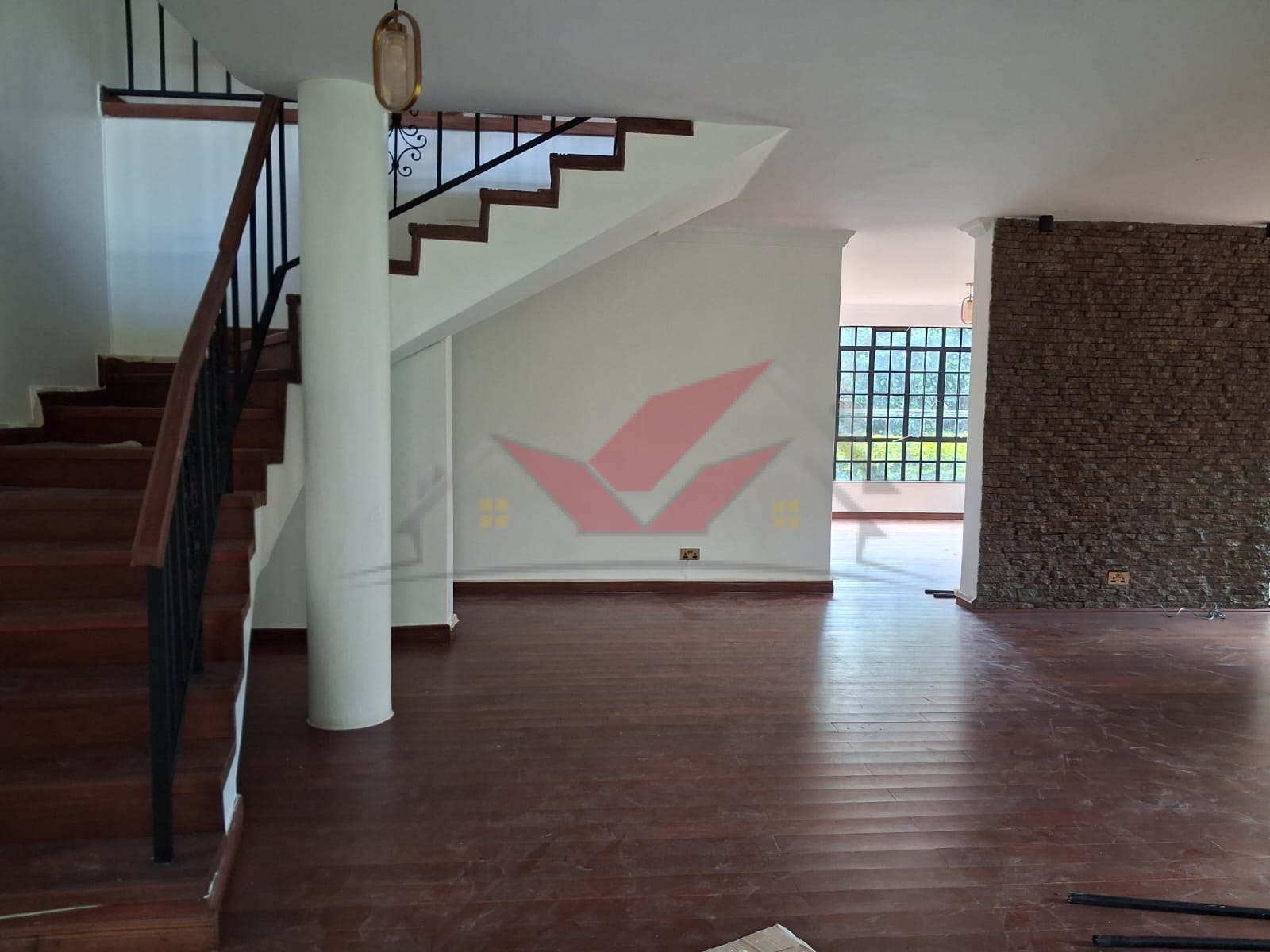 Grand living room with hardwood floors and fireplace in a luxury Karen rental.