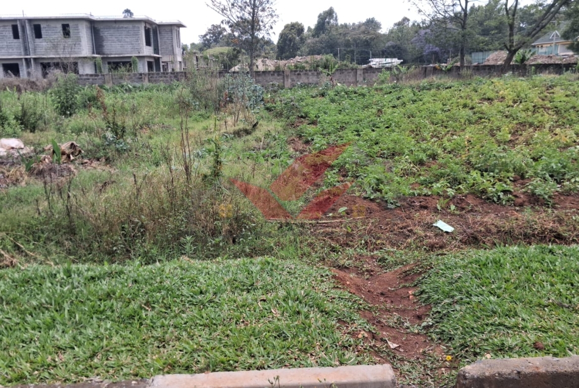Flat half-acre residential land for sale in Windyridge Karen featuring rich red soil and mature indigenous trees with a ready title deed .