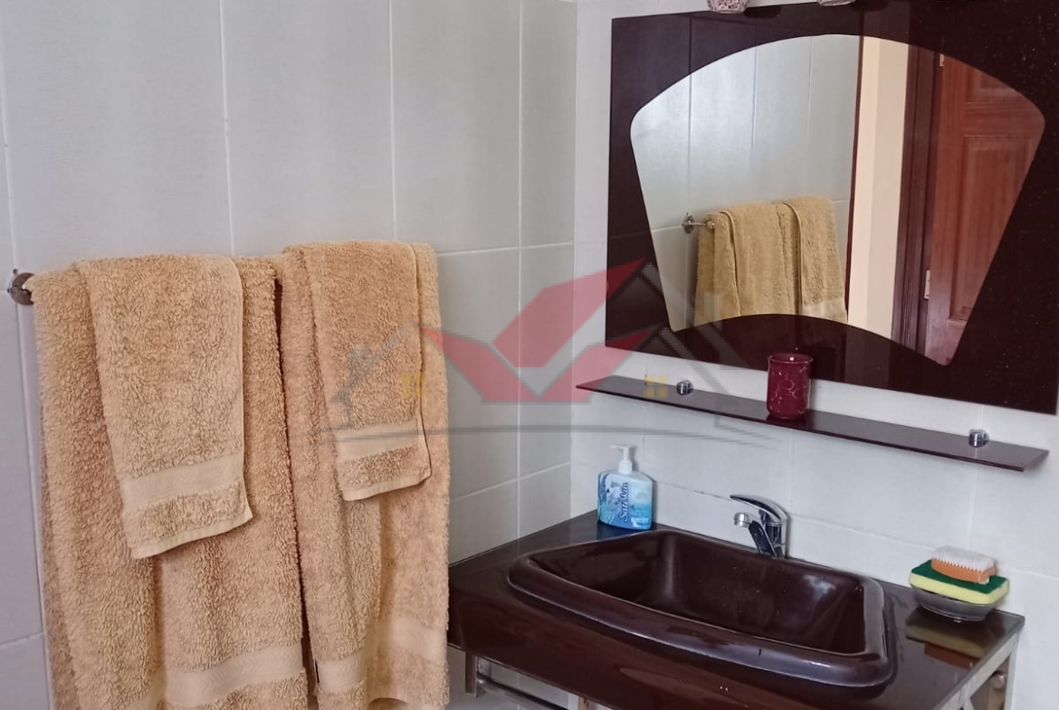 Cozy fully furnished living room and bedroom of a 1-bedroom rental cottage in Miotoni Karen Nairobi.