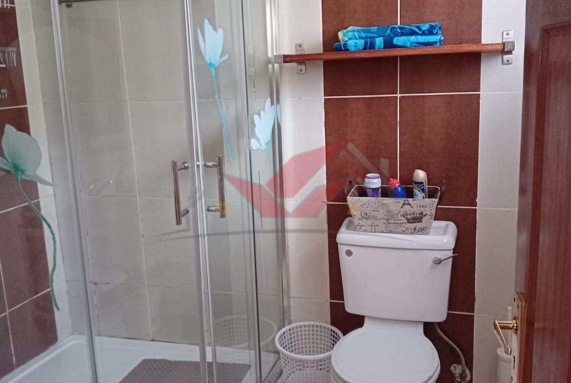 Cozy fully furnished living room and bedroom of a 1-bedroom rental cottage in Miotoni Karen Nairobi.